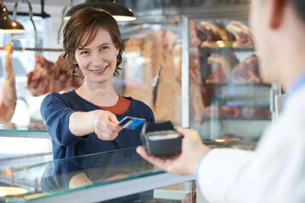 Cliente femenino pagando en carnicería usando tarjeta de crédito — Foto de Stock