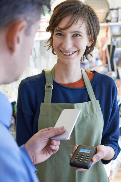 Man met contactloze betalingen App op de mobiele telefoon In de winkel — Stockfoto