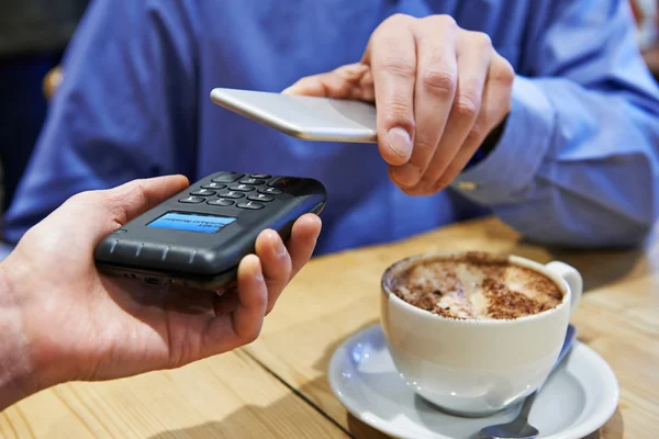 Hombre usando la aplicación de pago sin contacto en el teléfono móvil en el café — Foto de Stock