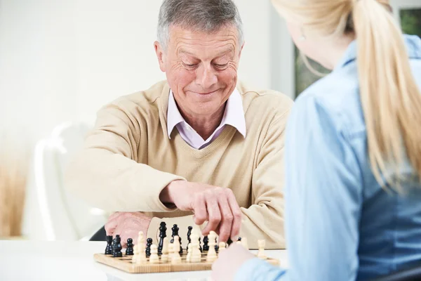 Старший игрок в шахматы с внучкой-подростком — стоковое фото