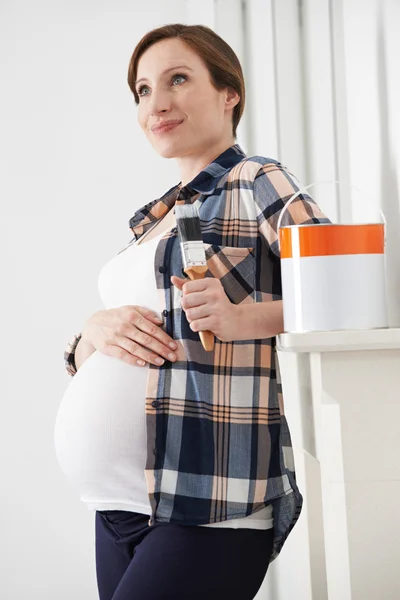 Gravid kvinna tar paus medan dekorera barnkammare — Stockfoto