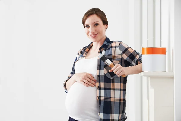 Retrato de mulher grávida decorando berçário — Fotografia de Stock