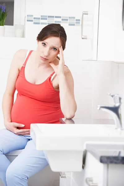 Mujer embarazada que sufre de náuseas matutinas en el baño — Foto de Stock