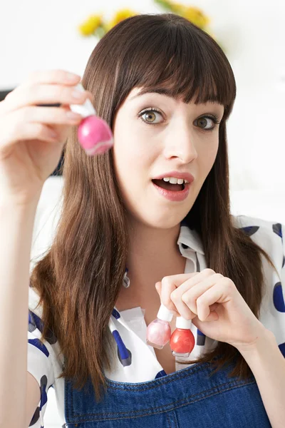 Joven mujer sosteniendo botellas de esmalte de uñas colorido —  Fotos de Stock