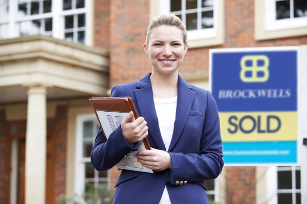 Porträt einer Immobilienmaklerin, die vor einem Wohnhaus steht — Stockfoto