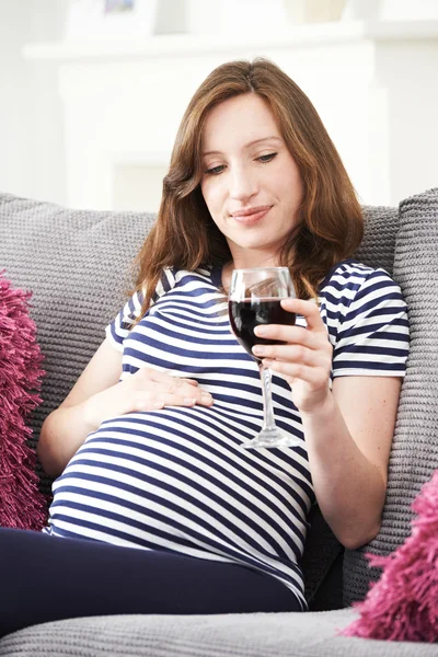 Pregnant Woman At Home Drinking Glass Of Red Wine Stock Image