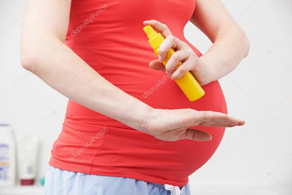 Pregnant Woman Spraying Mosquito Repellent To Protect Against Zi