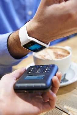 Kafede üzerinde akıllı temassız ödeme App kullanarak ödeme adam