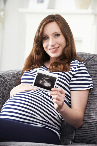 Retrato de mulher grávida segurando ultra-som varredura do bebê — Fotografia de Stock