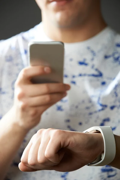 Jonge Man synchroniseren Smart Watch met mobiele telefoon — Stockfoto