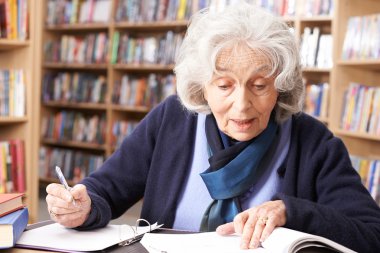 Kitaplığı'nda okuyan kadın kıdemli