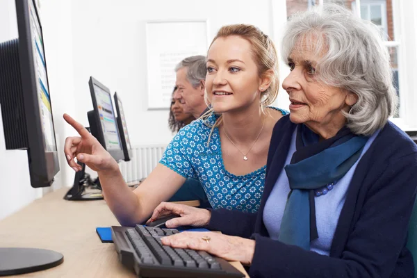 Tutorin hilft Seniorin im Computerkurs — Stockfoto