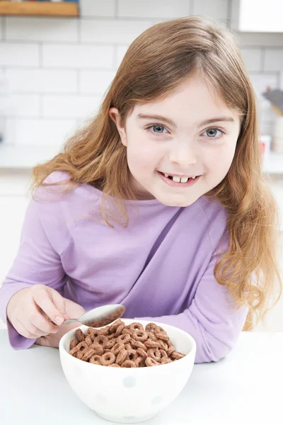 Chica comiendo tazón de cereales de desayuno azucarado en la cocina —  Fotos de Stock