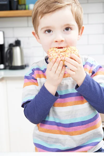 Joven comiendo rosquilla azucarada para merienda —  Fotos de Stock