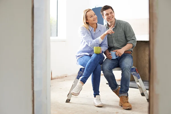 Casal sentado na propriedade a ser renovado — Fotografia de Stock