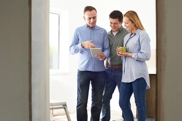 Reunión de pareja con arquitecto o constructor en propiedad renovada — Foto de Stock