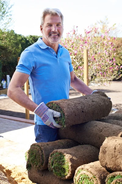 Paisaje jardinero que pone césped para el césped nuevo — Foto de Stock