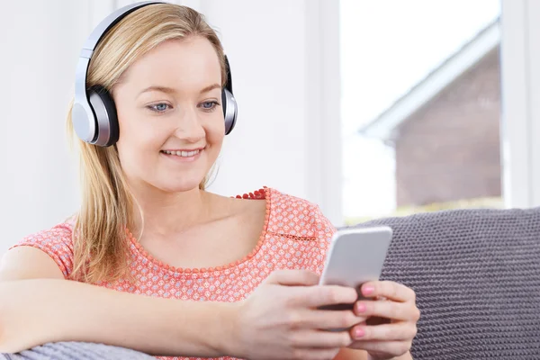 Kobieta umożliwia strumieniowe przesyłanie muzyki z telefonu komórkowego do bezprzewodowych słuchawek — Zdjęcie stockowe