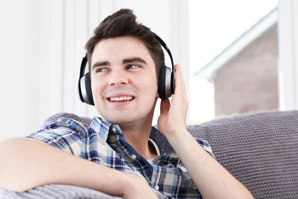 Joven escuchando música en auriculares inalámbricos — Foto de Stock