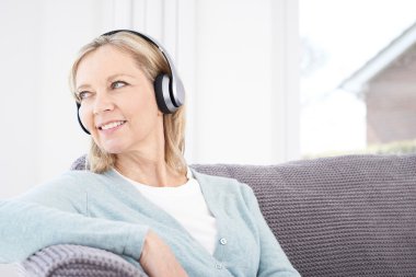 Olgun kadın kablosuz kulaklıklar müzik dinlemek
