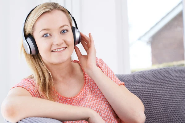 Ung kvinna lyssna på musik på trådlösa hörlurar — Stockfoto