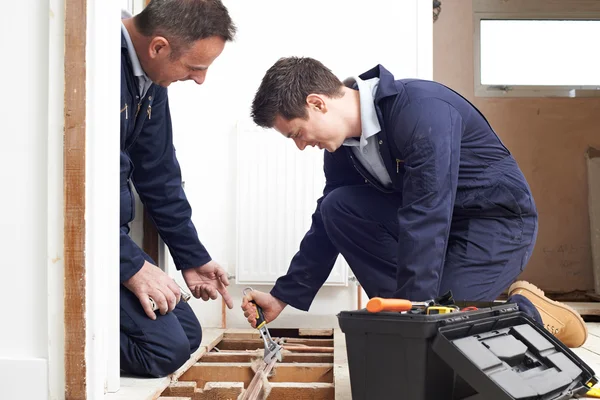 Fontanero y aprendiz instalando calefacción central en casa —  Fotos de Stock