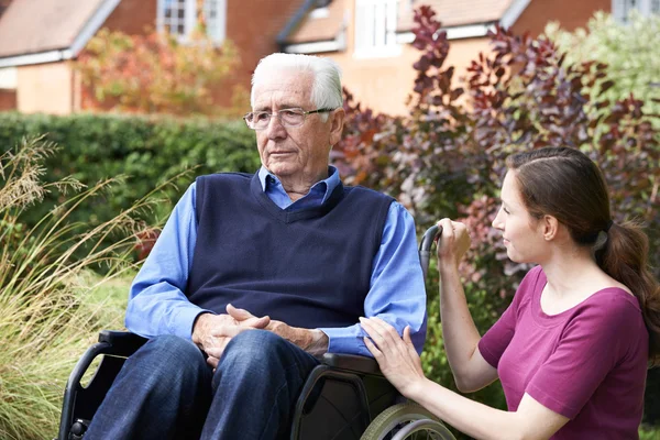 Hija adulta Consolando al padre mayor en silla de ruedas —  Fotos de Stock