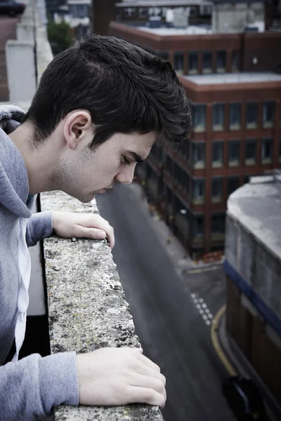 Jeune homme déprimé contemplant le suicide au sommet d'un grand bâtiment — Photo