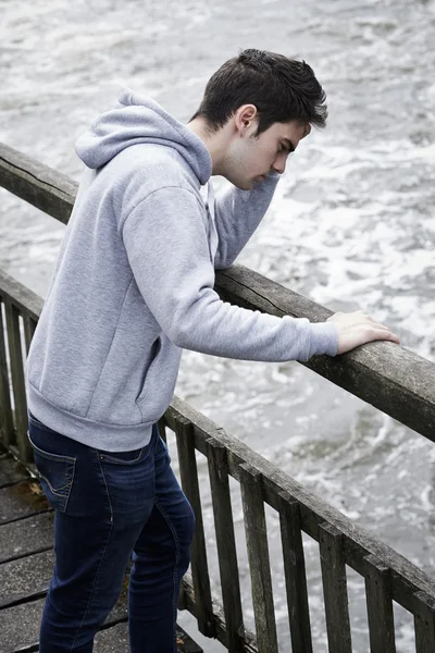 अवसादग्रस्त युवा आदमी नदी पर पुल पर आत्महत्या पर विचार कर रहा है — स्टॉक फ़ोटो, इमेज