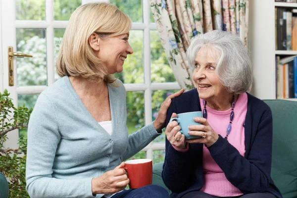 Vrouw nemen tijd voor een bezoek aan Senior vrouwelijke buurman en praten — Stockfoto