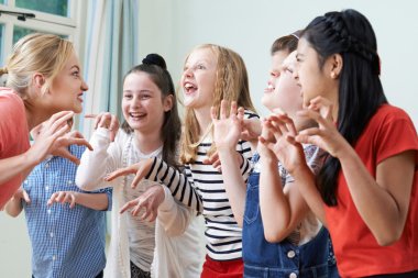 Group Of Children With Teacher Enjoying Drama Class Together clipart