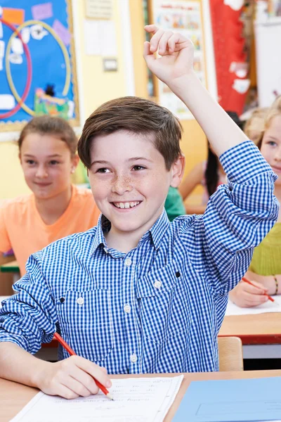 Uczeń, podnosząc rękę do odpowiedzi na pytanie na Klasa — Zdjęcie stockowe