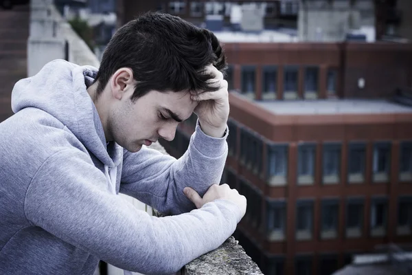 Joven deprimido contemplando suicidio en la cima de un edificio alto — Foto de Stock