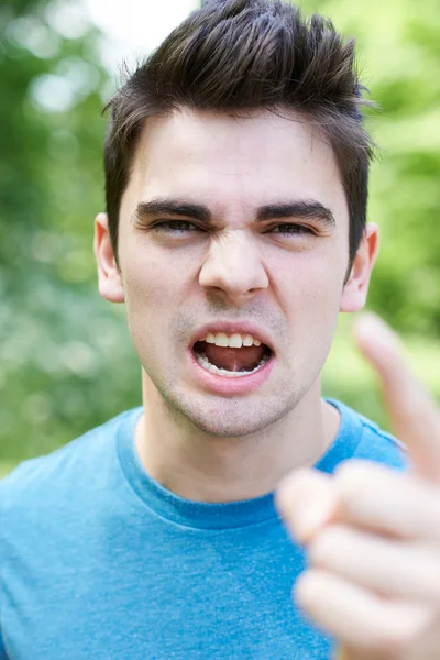 Cabeza y hombros al aire libre Retrato de hombre joven enojado — Foto de Stock