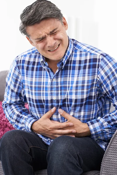 Uomo maturo che soffre di dolore allo stomaco a casa — Foto Stock