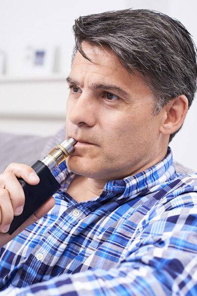 Mature Man Using Vapourizer As Smoking Alternative