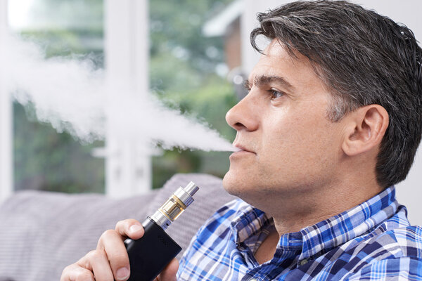Mature Man Using Vapourizer As Smoking Alternative