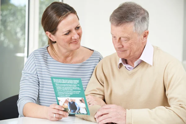 Hombre mayor con hija adulta mirando el folleto para jubilados —  Fotos de Stock
