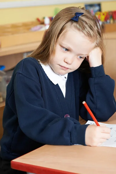 Étudiante ennuyeuse de l'école primaire au bureau — Photo