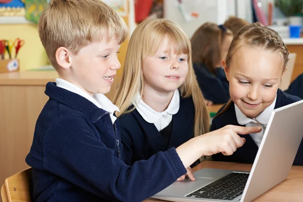 Группа детей начальной школы, работающих вместе за компьютером — стоковое фото