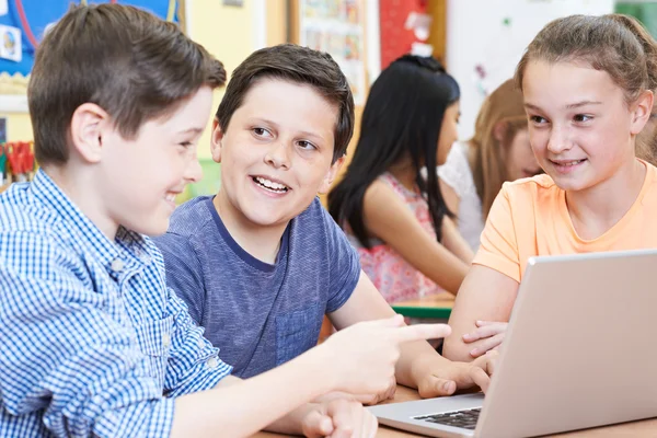 Группа детей начальной школы, работающих вместе за компьютером — стоковое фото