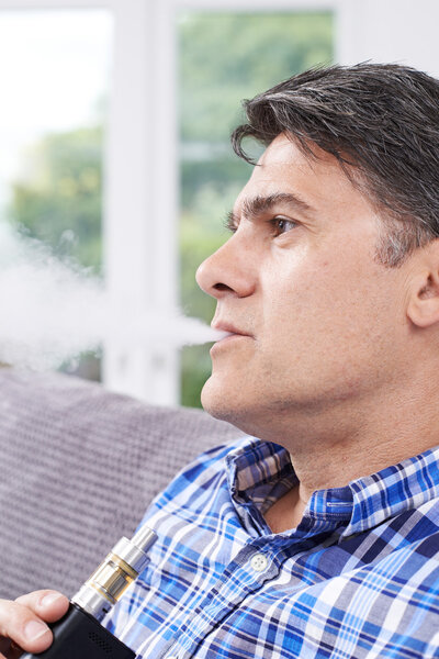 Mature Man Using Vapourizer As Smoking Alternative
