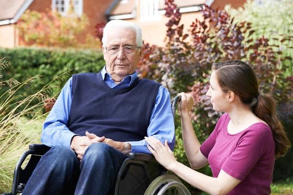 Vuxen dotter tröstande Senior far i rullstol — Stockfoto