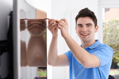 Engineer Fitting Curved Screen Television In Home clipart