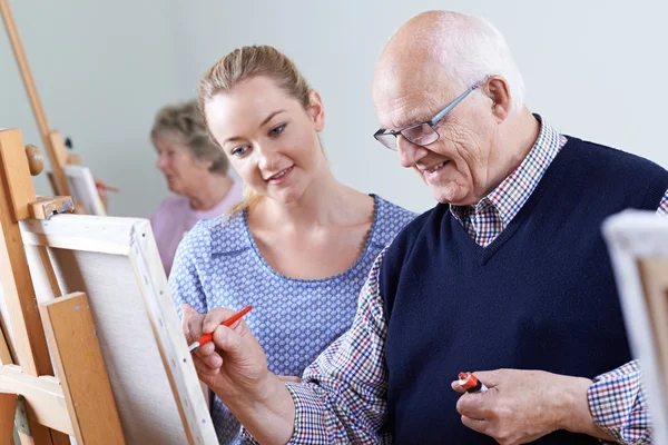 Anziani che frequentano corso di pittura con insegnante — Foto Stock