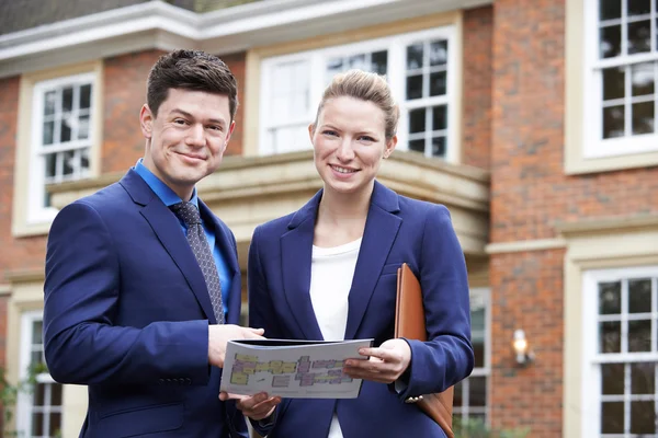 Male And Female Realtor Standing Outside Residential Property — Stock Photo, Image