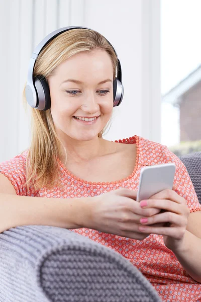 Kvinnan strömmar musik från mobiltelefonen till trådlösa hörlurar — Stockfoto