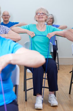 Grup yaşlılar Direnç Bands Fitness sınıfta kullanarak