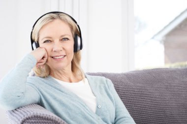 Olgun kadın kablosuz kulaklıklar müzik dinlemek