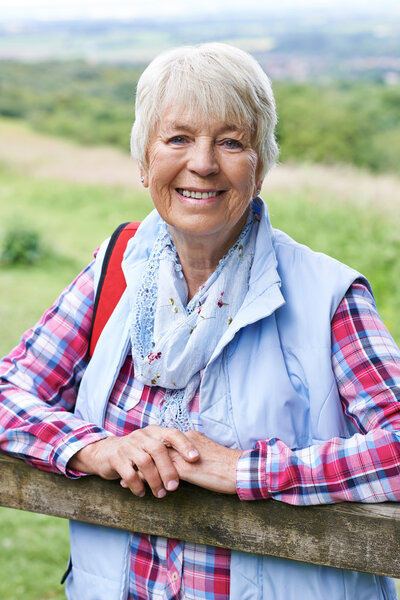 Portrait Of Senior Woman Hiking In Countryside